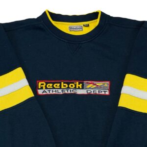 Pánský tmavě modrý vintage reworked crewneck značky Reebok s nášivkou loga na přední straně.. Reebok Reworked Dark Blue Yellow Crewneck